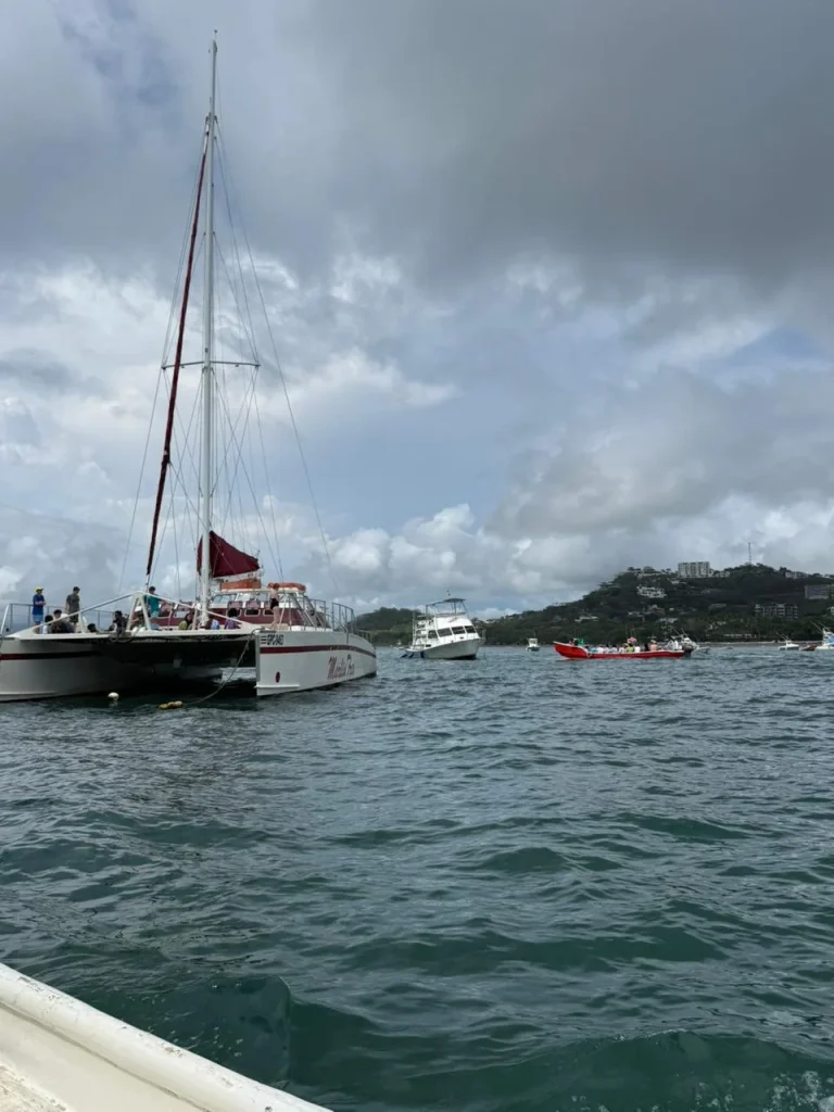 A catamaran with people on board sailing in the water