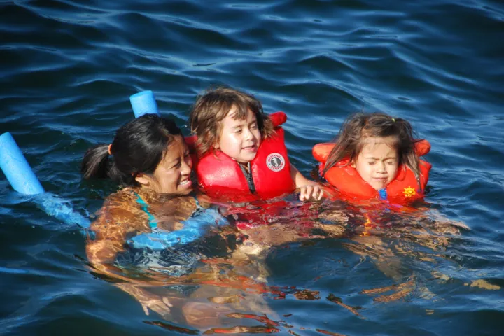 kids playing in water with life vests